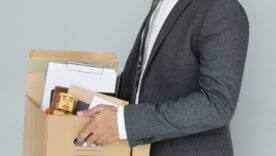 Image of man carrying box after being let go at work