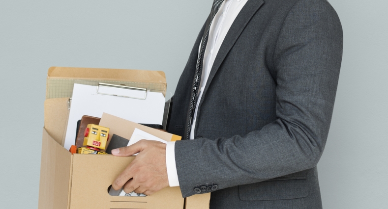 Image of man carrying box after being let go at work