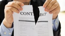Male in a business suit ripping up a contract