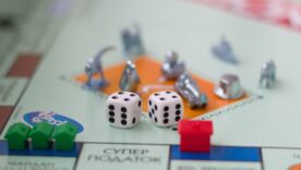 Monopoly board with green and red houses and dice on top