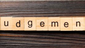Wooden table with wooden blocks with word judgement written out on the blocks