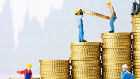 Pile of gold coins with construction toys climbing on the coins