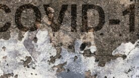 A wall with the words COVID-19 written on it