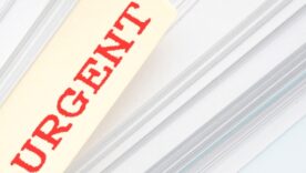 Pile of paper with a file tag sticking out with the word URGENT written in red on it