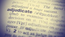 Dictionary page with the word adjudicate lit up