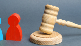 Two figures of people opponents stand near the judge's gavel.