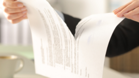 Close up of business woman hands breaking contract document