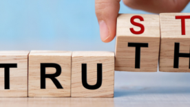 Businessman hand change wooden cube block with TRUST and TRUTH business word on table background