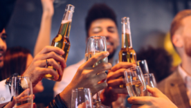 Group of friends cheering with champagne and beer