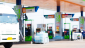 Gas station with a truck and cars blurred into the background