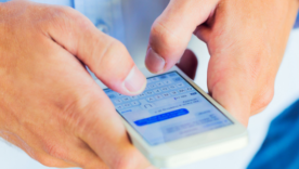 Close up of a man's hands texting from a cellphone