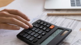 Close up cropped view of young woman enterpreneur hands doing financial paperwork check money savings sum on bank account calculating goods service price paying bills