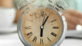 Crumbling alarm clock on white table in office