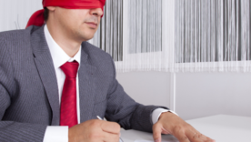 Blindfold businessman at the office working signing a contract