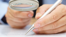 businessman analyzing a contract through a magnifying glass