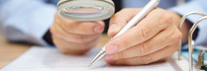 businessman analyzing a contract through a magnifying glass