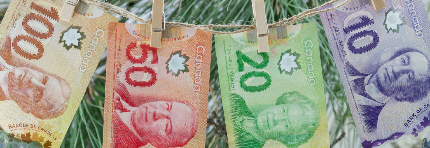 Canadian dollar bills hanging on a thread with a wooden clothespins