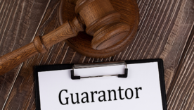 GUARANTOR text on paper with gavel on the wooden background