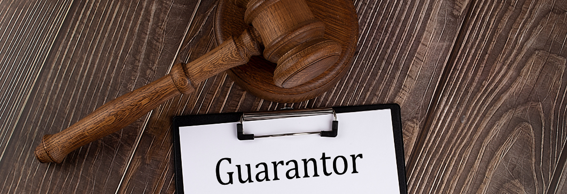GUARANTOR text on paper with gavel on the wooden background
