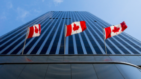Three Canadian flags in front of a business building in Ottawa, Ontario, Canada.