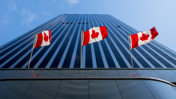 Three Canadian flags in front of a business building in Ottawa, Ontario, Canada.