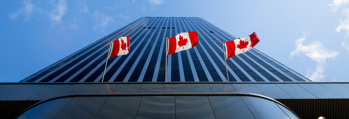 Three Canadian flags in front of a business building in Ottawa, Ontario, Canada.