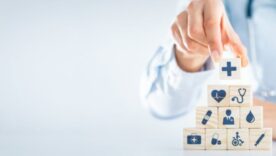 Hand arranging wood block with healthcare medical icon.