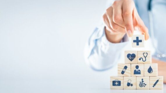 Hand arranging wood block with healthcare medical icon.