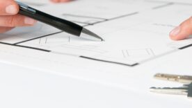 Closeup view of keys and drawing plan during a discussion with a real estate agent
