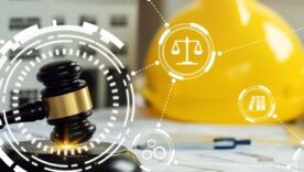 judge gavel on building blueprint plans with a yellow safety helmet and building model with law icons