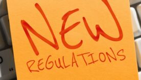 Writing on a post-it note displaying the text "New Regulations"