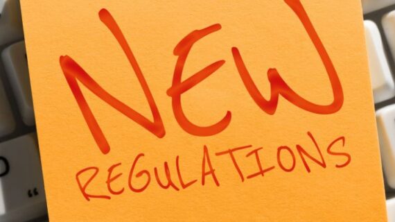 Writing on a post-it note displaying the text "New Regulations"