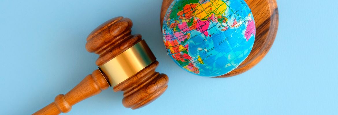 International law concept - judges gavel and globe on blue background