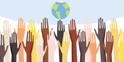 Group raised human arms and hands with a globe in the background - depicting diversity