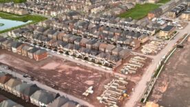 Aerial view of an Oakville suburban neighborhood featuring rows of homes, a small pond, and construction sites in a dirt area.