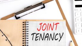 JOINT TENANCY text on paper with calculator, notepad, coffee ,pen with graph