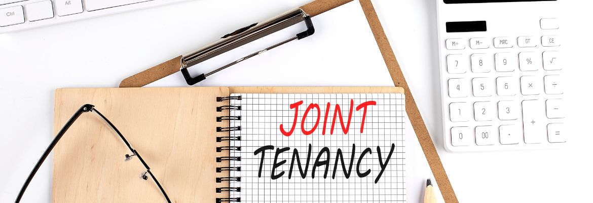 JOINT TENANCY text on paper with calculator, notepad, coffee ,pen with graph