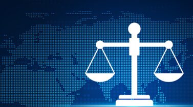 Digital scales of justice icon over a blue pixelated world map background, symbolizing global law and balance.